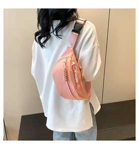 Detailed back view of pink nylon waterproof waist bag with black plastic buckle and cord zippers