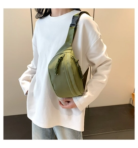 Detail of army green nylon belt bag with corded zipper pulls on a casual female model