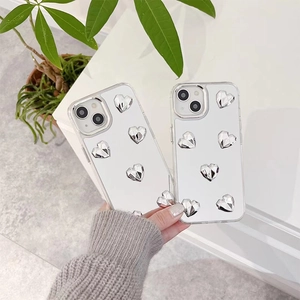 Coque iPhone transparente avec cœurs argentés 3D tenue en main sur fond blanc