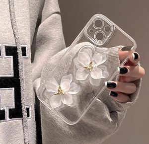 Détail de la coque iPhone transparente avec fleurs 3D blanches et accents dorés