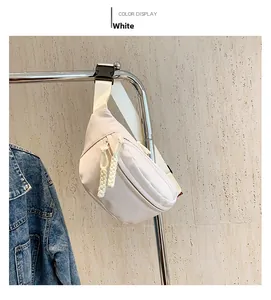 Detailed view of white nylon waist bag with main zipper and woven cord pulls