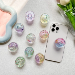 Star-filled donut phone grip with colorful sequins and collapsible resin design
