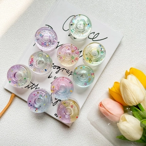 Close-up of star sequins and glitter inside resin phone grip on a white book