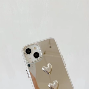 Macro detail of silver mirror iPhone case featuring 3D liquid metal heart decorations