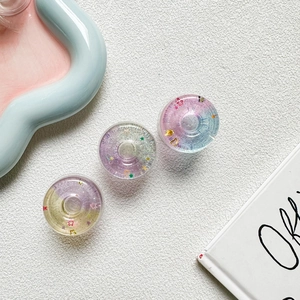 Detailed macro view of three sparkling star donut phone grips in colorful glitter resin
