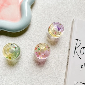 Detail of colorful transparent donut star phone grips with shimmering glitter filling