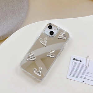 Détail d'une coque iPhone miroir avec cinq cœurs 3D en métal liquide sur plaque argentée