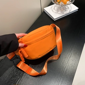 Bright orange nylon sports waist bag with adjustable strap and decorative zipper pull