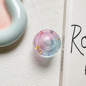 Close-up of a star-shaped glitter phone grip with pink and blue gradient resin