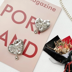 Macro view of crystal bowknot heart phone grip with sparkling rhinestones and teardrop pendant