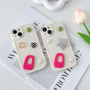Creamy white iPhone case with resin heart, star and pearl charms on an aesthetic magazine