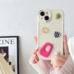 Detail of cream iPhone case with 3D resin heart, pearl, and colorful geometric charms