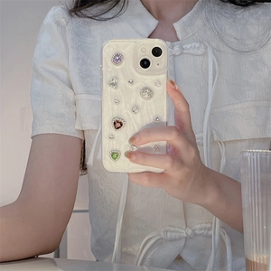Chic wavy iPhone case in cream white featuring vibrant rhinestones and heart gemstones