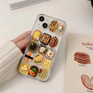 Close-up of 3D miniature food models like sushi and sandwiches on a clear iPhone case