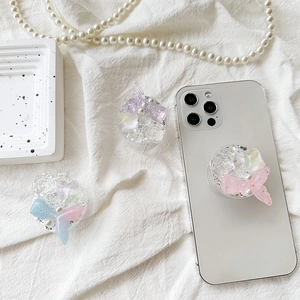 Floral resin phone grip set with pearls and sequins on a white textured background