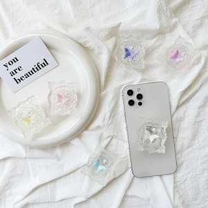 Transparent butterfly phone socket stand with vintage frame and pearl accents on white fabric