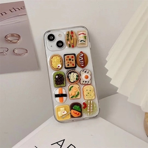 Detailed close-up of 3D sandwich and sushi food charms on a clear phone case