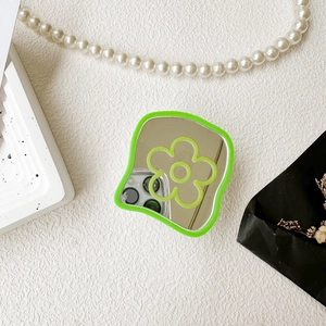 Detail of flower pattern on green scalloped cell phone mirror grip with aesthetic props