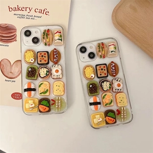 Close-up of 3D miniature sandwich and sushi food charms on transparent iPhone case