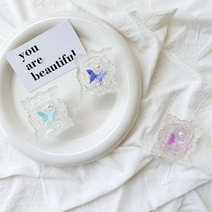 Detailed view of resin phone grips featuring colorful butterflies and faux pearls