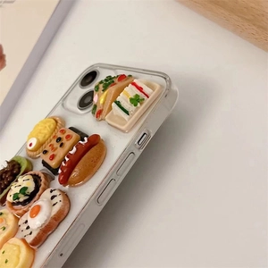Detailed close-up of 3D miniature food charms on a clear protective iPhone phone case