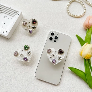 Detail view of heart-shaped colorful rhinestone pop grip phone holder with jewel accents