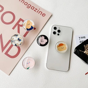 Crystal glass phone grip with cute cartoon bear and peach design on a white iPhone