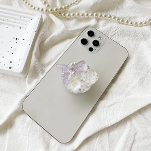 Floral pearl phone grip with purple fishtail and sequins on a white smartphone
