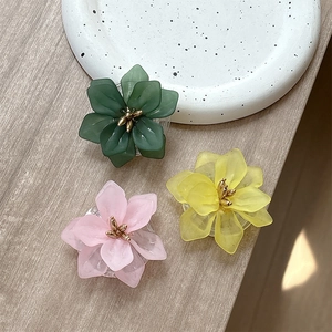 Floral phone grip sockets in green, pink, and yellow lotus design on wood background