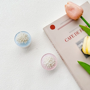 Close-up of pearl round phone socket stands in pink and blue on a vintage background