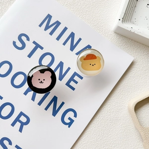 Close-up of cute bear design crystal glass collapsible phone socket grips on a desk