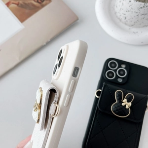 Detail view of iPhone cases with quilted rabbit pouch and side metal hanging rings