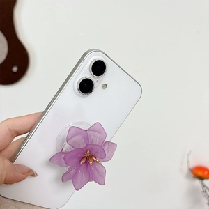 Detailed view of a purple flower phone grip with gold stamen on a white smartphone