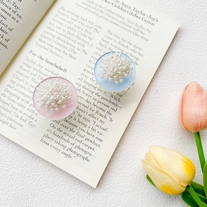 Detail view of round cell phone sockets with clustered white pearls and pastel base