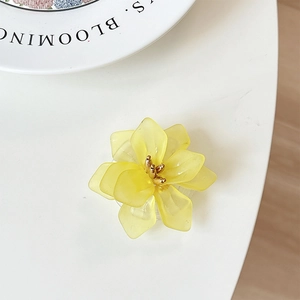 Detail view of a yellow flower phone grip with matte petals and golden center core