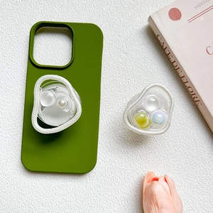 Close-up of pearl bead mobile grip stand on a green phone case with elegant floral backdrop