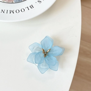 Macro detail of a light blue flower phone grip with matte resin petals and golden stamen