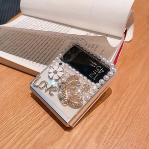 Luxurious Samsung Z Flip clear case with pearl trim, crown, and enamel flower detail