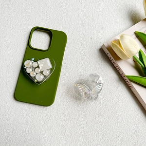 Detail of dark green phone case with heart resin pop socket and glitter butterfly