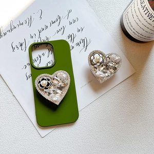 Detailed view of luxury camellia pearl heart phone grip on avocado green case