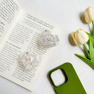 Close-up of heart-shaped phone grips with laser butterfly and pearl embellishments