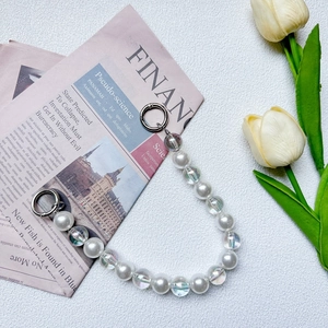 Macro shot of faux pearl and iridescent bead strap with silver ring buckles for handbags