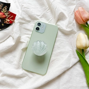 Pink glitter seashell folding phone socket mount on a light green smartphone