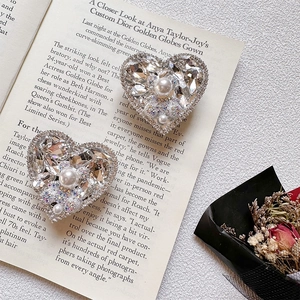 Detailed macro shot of luxury heart phone grip with sparkling rhinestones and white pearls