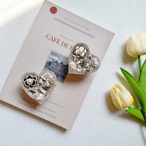 Detail of luxury heart-shaped phone grip with camellia flowers and pearl rhinestones
