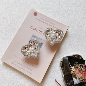 Macro detail of luxury heart phone grip with rhinestones and pearl on a pink book