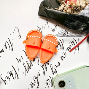 Close-up of cute orange shark phone grips in 3D silicone on a stylish minimalist background