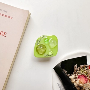 Detail of green resin phone grip with 'gift of future' text and crystal stone inlay