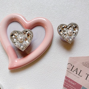 Close-up of heart-shaped phone socket with luxury pearls and sparkling rhinestones
