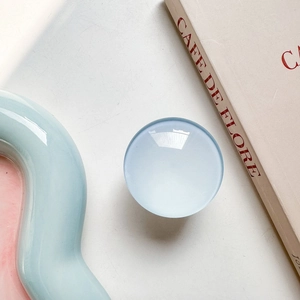 Detail of round light blue glass phone grip on a minimalist lifestyle background scene